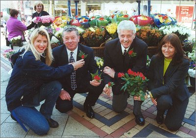 FLOWER GIRL KIRSTYN STOKES, FIANCE OF FLOWER STALL OWNER JIM MCEVOY, SHOWS RED ROSES TO ROGER BACHE, PATRICK FOX AND TONI GARRATT OF THE CITY CENTRE COMPANY